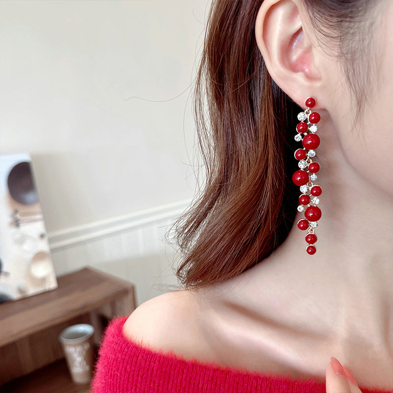 2025 Chinese retro red New Year's earrings, long temperament showing face, thin studs, exaggerated simple and versatile pearl earrings.